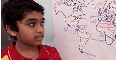Amar beside a hand-drawn world map labelled with countries and rivers, from the CollegeDekho profile of his Learn With Amar channel
