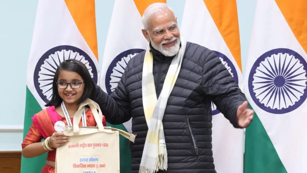 Charvi Anilkumar with Prime Minister Narendra Modi, holding her Pradhan Mantri Rashtriya Bal Puraskar 2024 tote bag printed with her name
