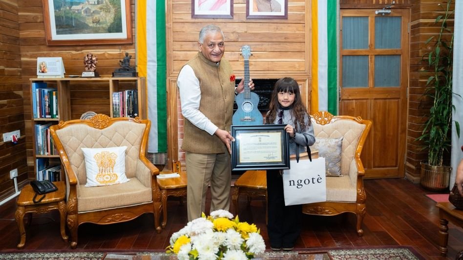Esther Hnamte with the Governor of Mizoram, holding her framed Bal Puraskar certificate, her ukulele beside her
