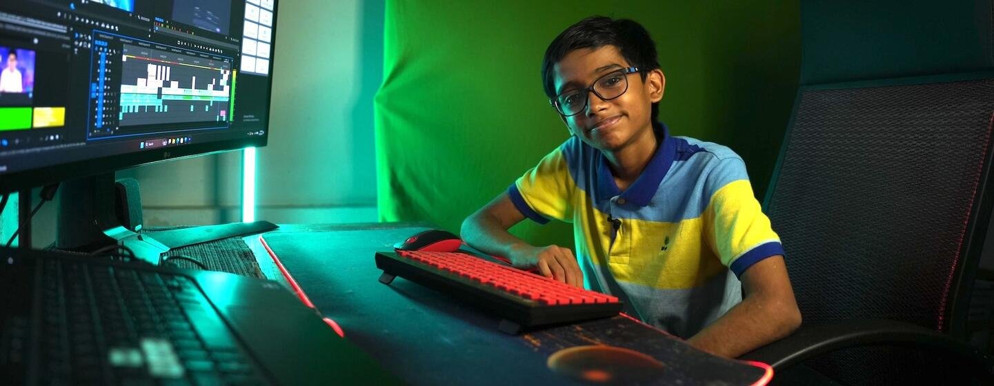 Raul John Aju at a computer, in the UN News interview