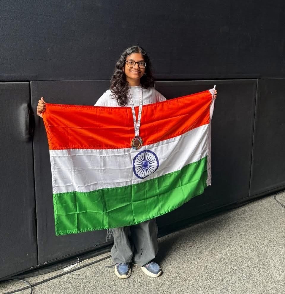 Swasti Patil holding the Indian flag and wearing her EGOI-2025 bronze medal