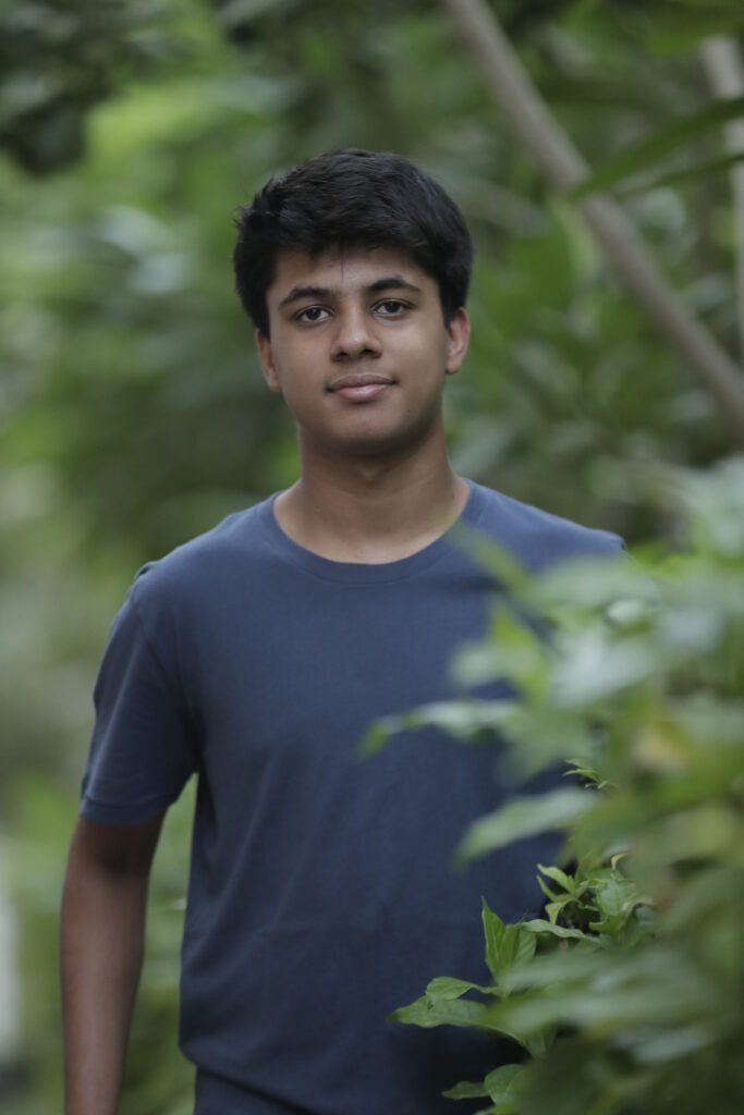 Vihaan Agarwal standing among trees and greenery — the cover portrait of Stanford Global Health’s profile of him