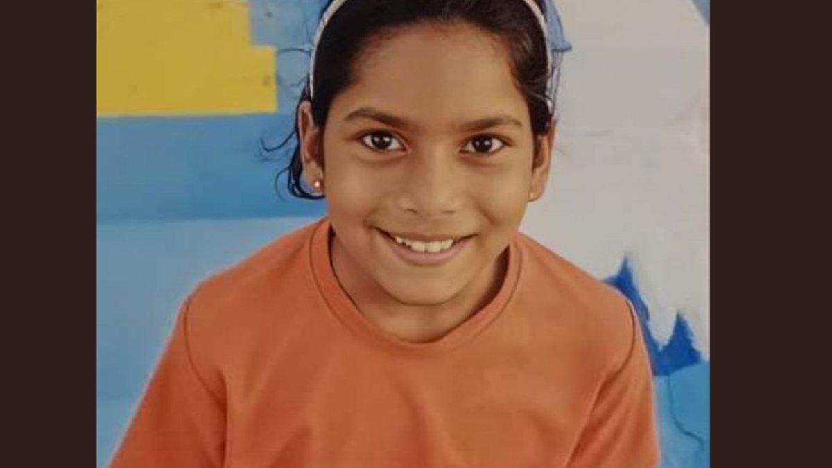 Vyoma Priya smiling in an orange T-shirt and hairband against a painted wall — the portrait published with The Times of India’s memorial profile of her